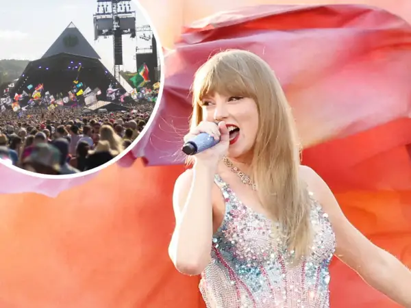 Taylor Swift singing on stage at Glastonbury festival with a large crowd and pyramid stage in the background.