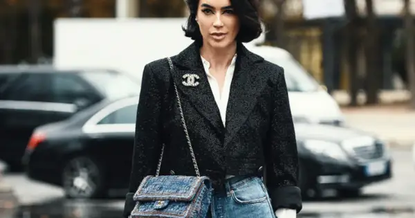 Elegancka kobieta w tweedowej marynarce i jeansach, z torebką Chanel. Klasyczne coco chanel stylizacje.