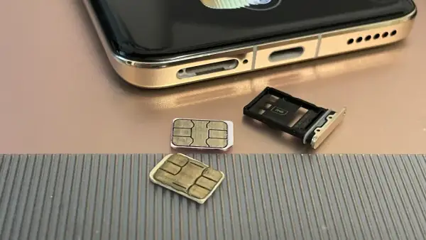 Dwie karty SIM i tacka na karty obok telefonu. Czy można mieć dwie karty SIM z tym samym numerem? To pytanie nurtuje wielu użytkowników.