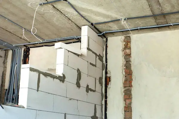 Ścianki działowe na poddaszu z bloczków gazobetonowych, z widocznym układem instalacji elektrycznej. Widać, jak wysoko murować ścianki działowe na poddaszu, by zapewnić miejsce na przewody.