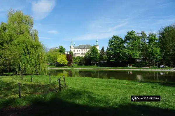Piękny dzień w Kielcach. Pałac Biskupów Krakowskich nad stawem, otoczony zielenią. Idealne miejsce na spacer.