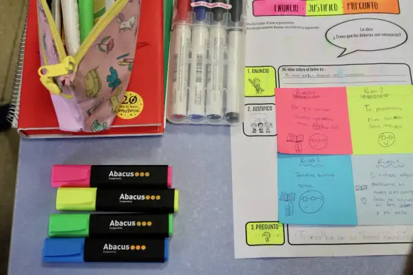 Materiales para escriptura creativa cicle inicial: rotuladores, libreta, lápices y notas adhesivas con ideas sobre deberes.