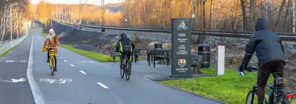 Rowerzyści na ścieżce wzdłuż torów kolejowych. Nowoczesne trasy rowerowe Śląsk zachęcają do aktywnego wypoczynku.