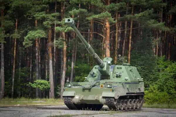 Zielona armata samobieżna, niczym współczesny rzymski bóg wojny, stoi na tle sosnowego lasu, gotowa do akcji.