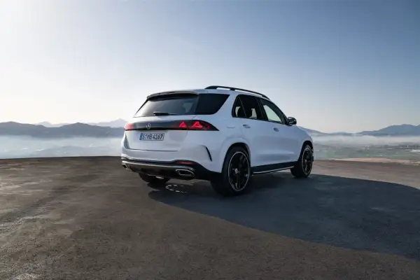 Biały Mercedes GLE 2026 z czarnymi felgami na tle górskiego krajobrazu.