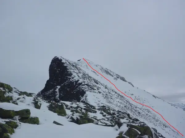 Snöklädda bergstoppar med en röd markerad led som leder uppåt. En utmanande sylarna topptur i vinterlandskap.