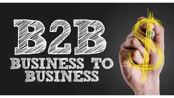 Mano disegna simbolo dollaro su lavagna con scritta "B2B Business to Business", il significato di B2B nel mondo degli affari.