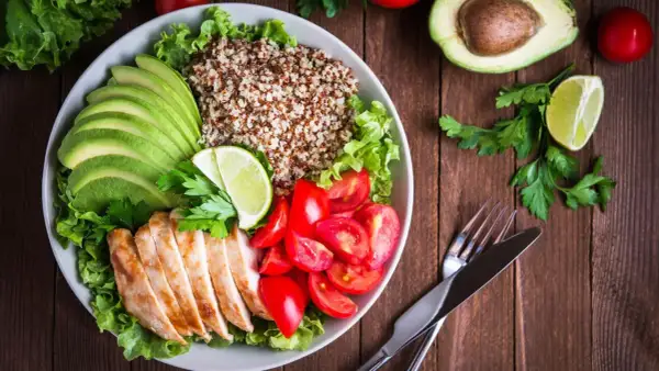 Schüssel mit Quinoa, Hähnchenbrust, Avocado, Tomaten und Salat. Ein leicht verdauliches Essen, das gut aussieht und schmeckt.