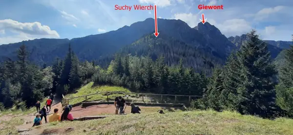 Ludzie na szlaku w Tatrach, widok na Suchy Wierch i Giewont. Trasa sarnia skała.