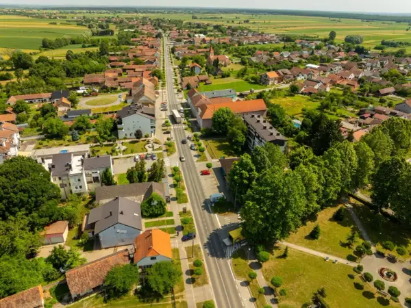 Widok z lotu ptaka na spokojne miasteczko, gdzie zielone pola przeplatają się z dachami domów. Odkryj urokliwe śrem atrakcje i poczuj atmosferę sielskiego życia.