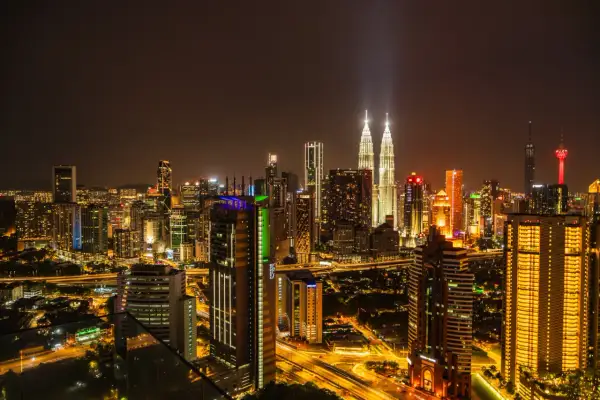 Nocna panorama Kuala Lumpur z wieżami Petronas. Kiedy najlepiej lecieć do Kuala Lumpur? Warto rozważyć okres od czerwca do września, gdy jest mniej deszczowo.