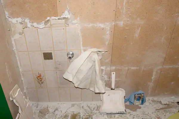 Renovierungsarbeiten: alte Fliesen werden entfernt, um Platz für neue zu schaffen. Staub und Schutt bedecken den Boden.