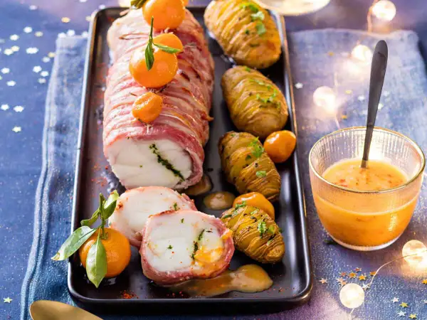 Lotte au lard, un plat festif du carnet de Julie, servi avec des pommes de terre Hasselback et une sauce orangée.