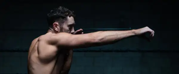 A boxer throws a powerful right jab, his muscles tensed and ready.