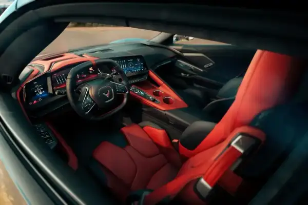 Wnętrze Chevrolet Corvette C8 z czerwono-czarnymi skórzanymi fotelami i nowoczesną deską rozdzielczą.