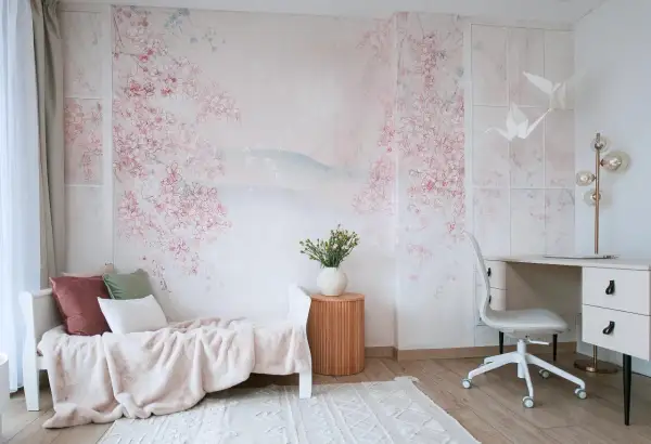 Delikatna fototapeta IKEA z kwitnącą wiśnią tworzy sielankową atmosferę w pokoju z łóżkiem i biurkiem.
