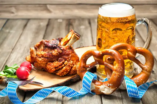 Un saporito stinco di maiale arrosto, due brezel e una birra bionda, un classico cibo da oktoberfest.