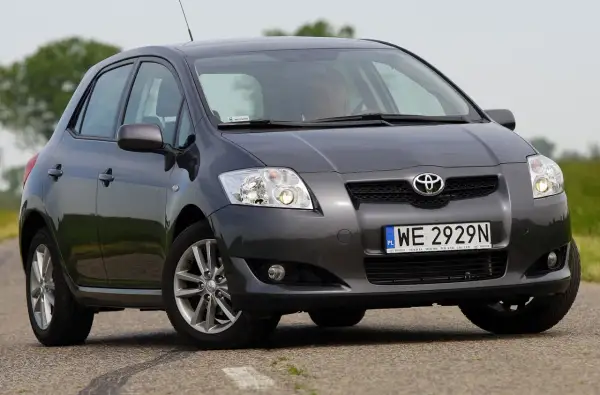 Szary Toyota Auris z przodu. Widać dwa światła cofania, jedno po każdej stronie zderzaka.