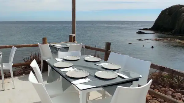 Mesas puestas en un restaurante de Almería con vistas al mar.