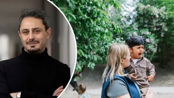 Devin Rexvid ser fundersam ut bredvid en kvinna som tröstar ett gråtande barn utomhus.