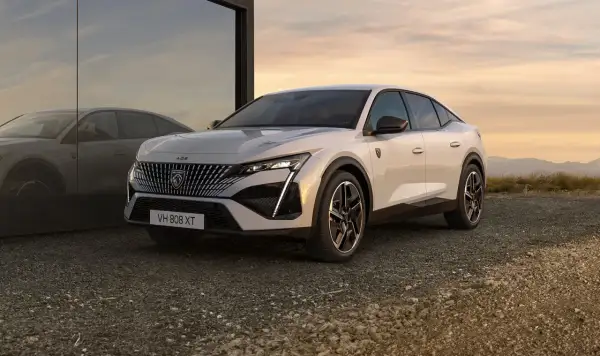 Nowy Peugeot 408 w kolorze białym, z charakterystycznym grillem i nowoczesnymi światłami. Sprawdź jego atrakcyjną peugeot 408 cenę.