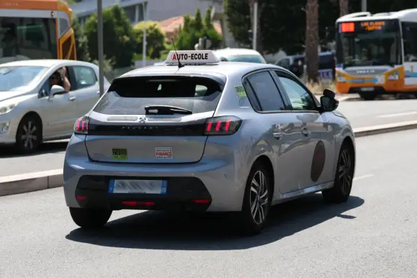 Voiture auto-école Peugeot 208 argentée, avec un autocollant "Votre permis B FINANCE grâce au CPF".