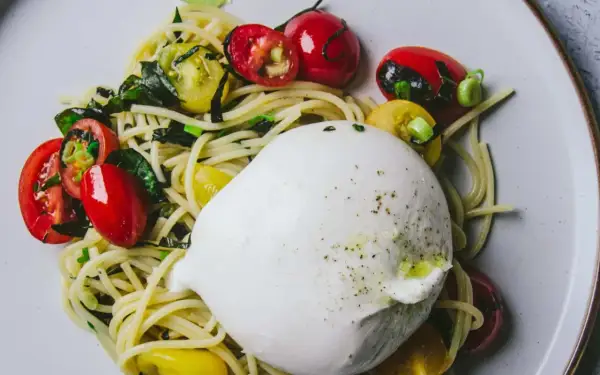 Une burrata crémeuse sur des pâtes aux tomates cerises et basilic. Une recette simple et savoureuse.