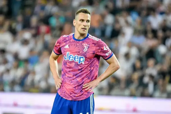 Piłkarz Arkadiusz Milik w różowej koszulce Juventusu z logo Jeep.