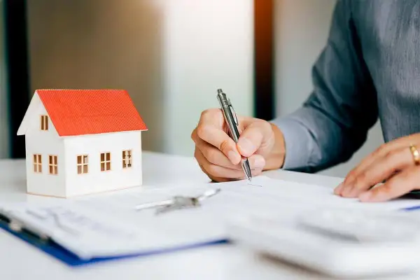 Firma contratto immobiliare: attenzione ai rischi nel vendere casa con agenzia. Modello casa, chiavi e firma su documento.