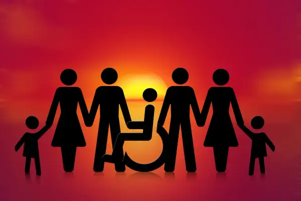 Famiglia unita al tramonto, con un membro su sedia a rotelle. Speranza per una pensione invalidità 800 euro.