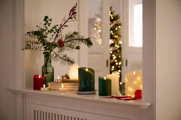 Gemütliche weihnachtsdeko tipps: Kerzen, Tannenzweige und Lichterketten schaffen festliche Stimmung.