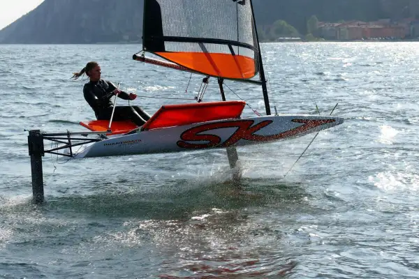 Vela da regata con foil che solleva lo scafo dall'acqua, creando un effetto simile a una falena in volo.