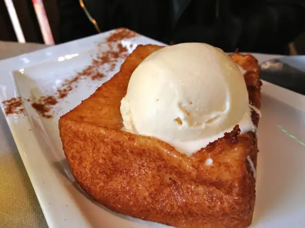 Torrijas zaragozanas con helado de vainilla, espolvoreadas con canela. Un postre delicioso.