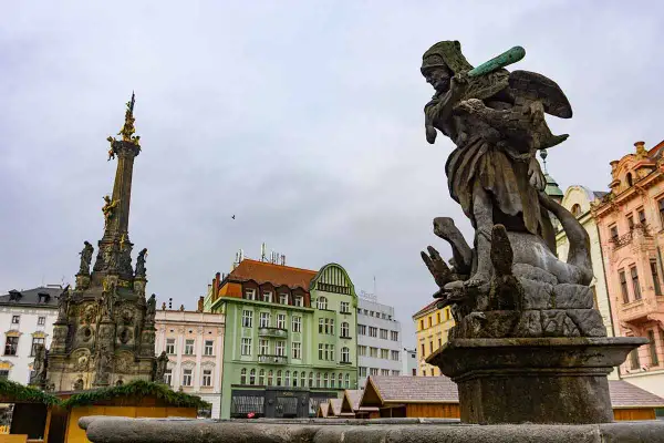 Fuente barroca y columna de la peste en Brno. Un buen lugar que ver en Brno, con edificios coloridos de fondo.