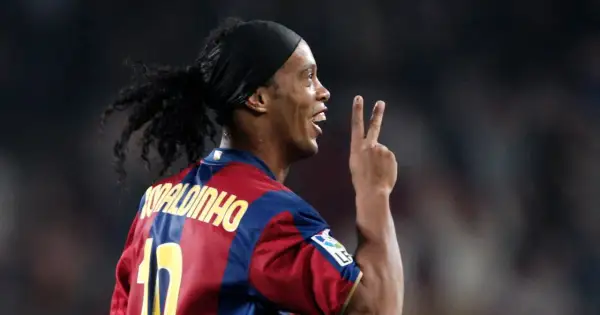 Ronaldinho w barwach FC Barcelony, klubu, w którym grał wiele lat. Pokazuje dwa palce, symbolizując zwycięstwo.