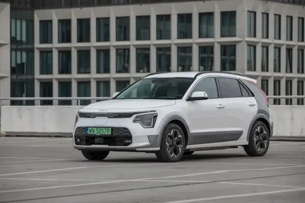 Białe Kia Niro stoi na parkingu. Sprawdź kia niro wymiary, by poznać jego kompaktowe gabaryty idealne do miasta.
