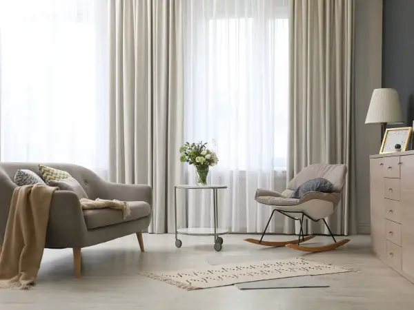 Elegantes tipos de cortinas para ventanas, con un sofá y mecedora en un salón moderno.