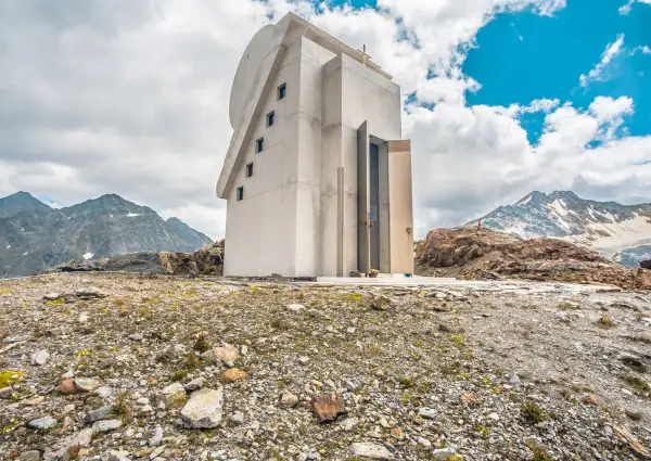 Moderne Kapelle am Pitztaler Gletscher, umgeben von felsiger Landschaft und schneebedeckten Bergen.