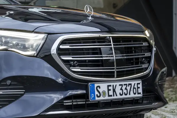 Dettaglio anteriore di un'auto di lusso con griglia cromata e fari a LED. La cromatura esterni risalta sulla carrozzeria scura.