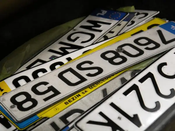 Stos tablic rejestracyjnych, w tym numerów z literami "SD" i cyframi "809", czeka na pch rejestracja.