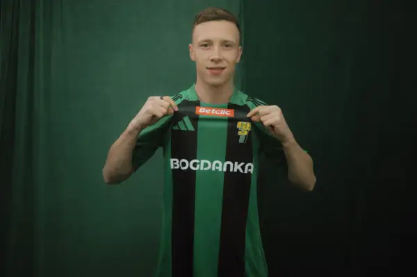 Młody piłkarz, którego miszor wiek sugeruje, że jest na początku kariery, prezentuje zielono-czarną koszulkę z logo Bogdanka.