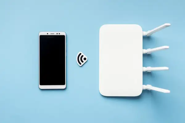Smartfon i router Wi-Fi obok symbolu sieci. To pokazuje, jak działa hotspot.