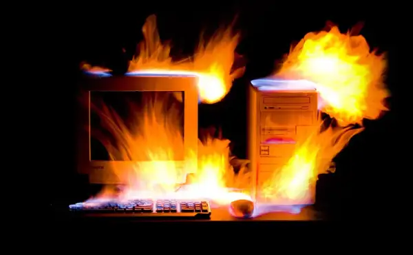 Płonący komputer z lat 2000. i klawiatura, jakby przegrzewały się od emocjonujących, **stare gry na PC lata 2000.**