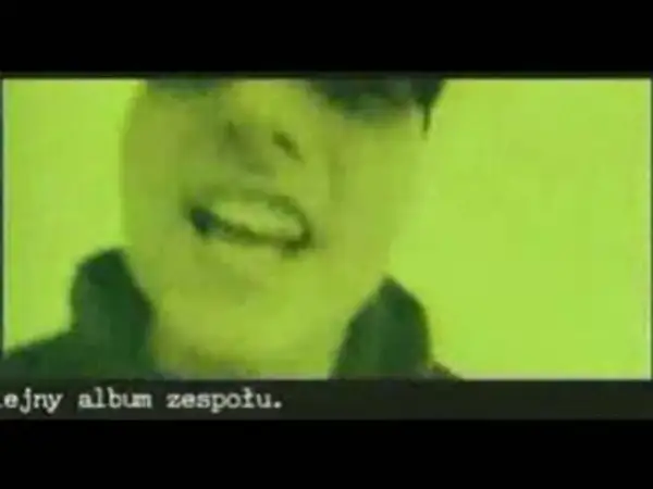 Fragment klipu zespołu Kaliber 44. Widać twarz rapera na zielonym tle. Tekst: "ejny album zespołu.