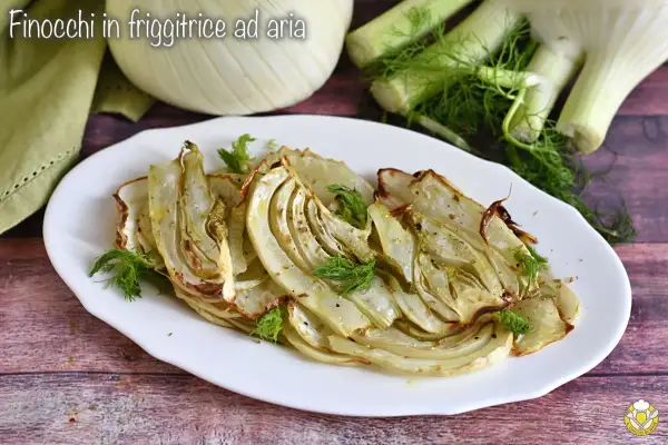 Finocchi in friggitrice ad aria, dorati e profumati, serviti su un piatto bianco con guarnizione di aneto fresco.