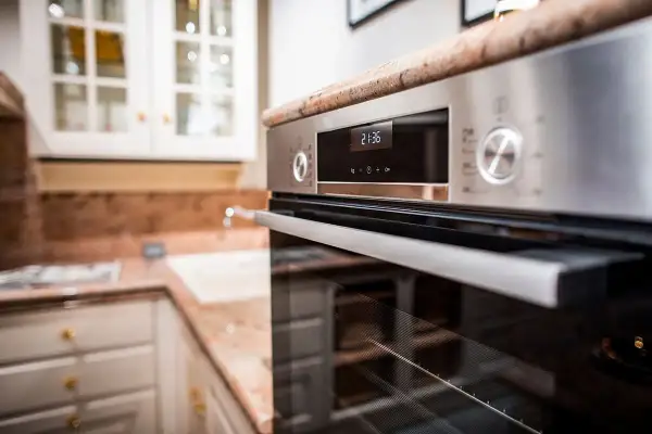 Forno moderno in acciaio inossidabile, con display digitale e manopole. Ideale per chi cerca come pulire il forno incrostato senza fatica.