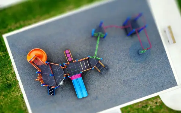 Nowoczesny plac zabaw z pomarańczową zjeżdżalnią i niebieskimi elementami. Czy plac zabaw wymaga pozwolenia na budowę?