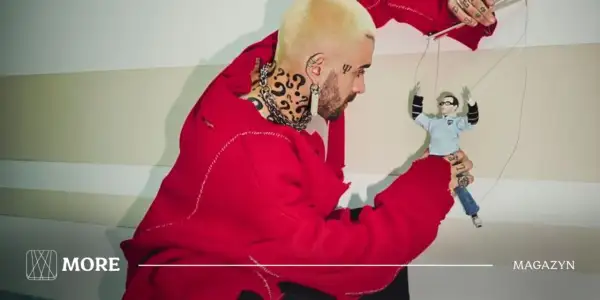 Quebonafide w czerwonym swetrze steruje marionetką, jakby tworzył swoje utwory.