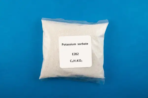 Zagrożenia związane z sorbinianem potasu E202. Biały proszek w woreczku z etykietą "Potassium sorbate".