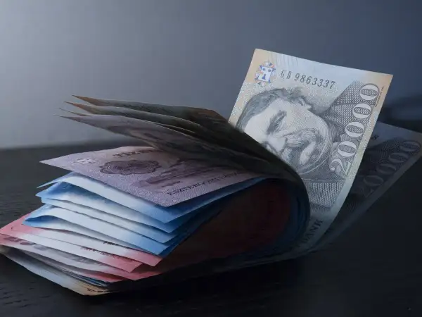 Stos banknotów forintów węgierskich, czyli czym płacić na Węgrzech. Widoczny portret mężczyzny na banknocie 20000 HUF.